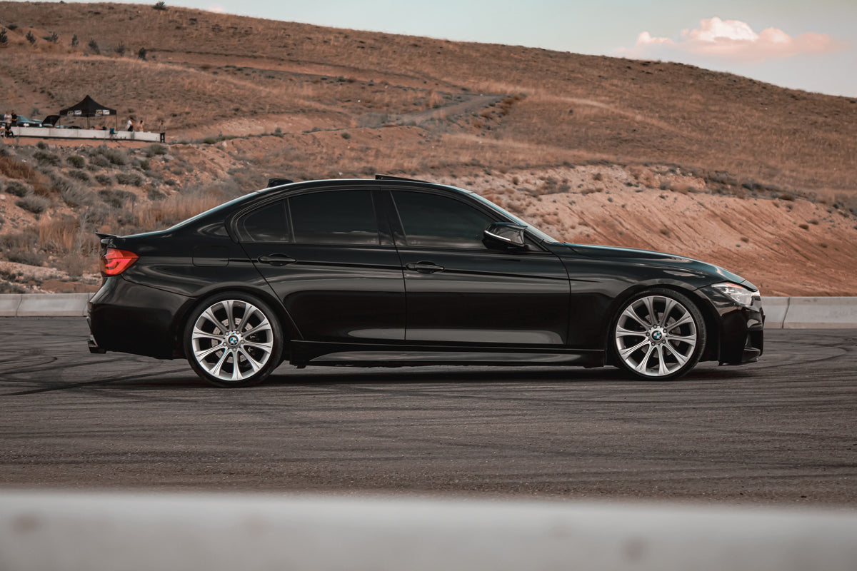 Black sedan with tinted side windows, photographed outdoors by Emre Aslihak. Stock lifestyle photo; not an exact film shade or customer installation.