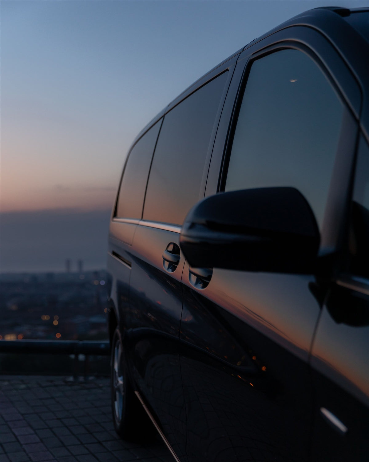 Close-up of dark side windows reflecting dusk light, photographed by George Sultan. Stock lifestyle photo; appearance is not an exact VLT sample.